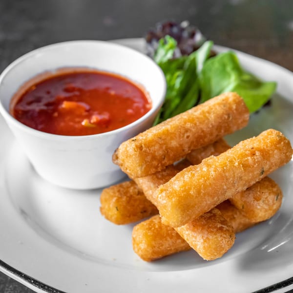 Golden-brown mozzarella sticks with a side of marinara sauce and a small green salad.